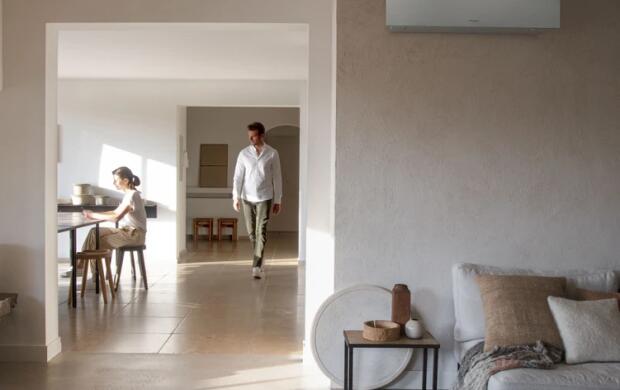 Moderne woonkamer met een man en een vrouw, zittend aan tafel, lichte en minimalistische inrichting.