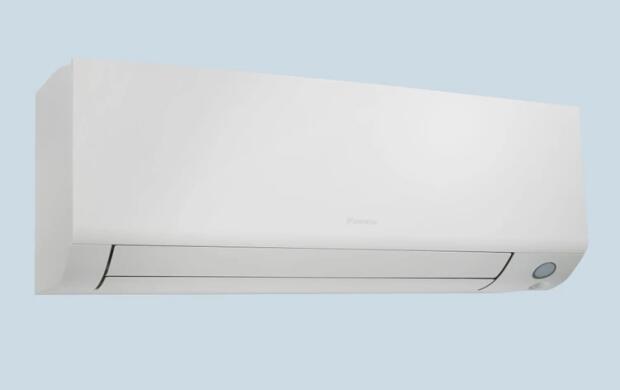 Een witte wand airconditioner tegen een lichtblauwe achtergrond.