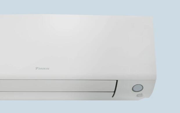 Een witte airconditioner tegen een lichtblauwe achtergrond.